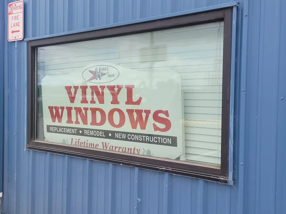 Hara’s Vinyl Windows sign in a window on the blue-sided shop